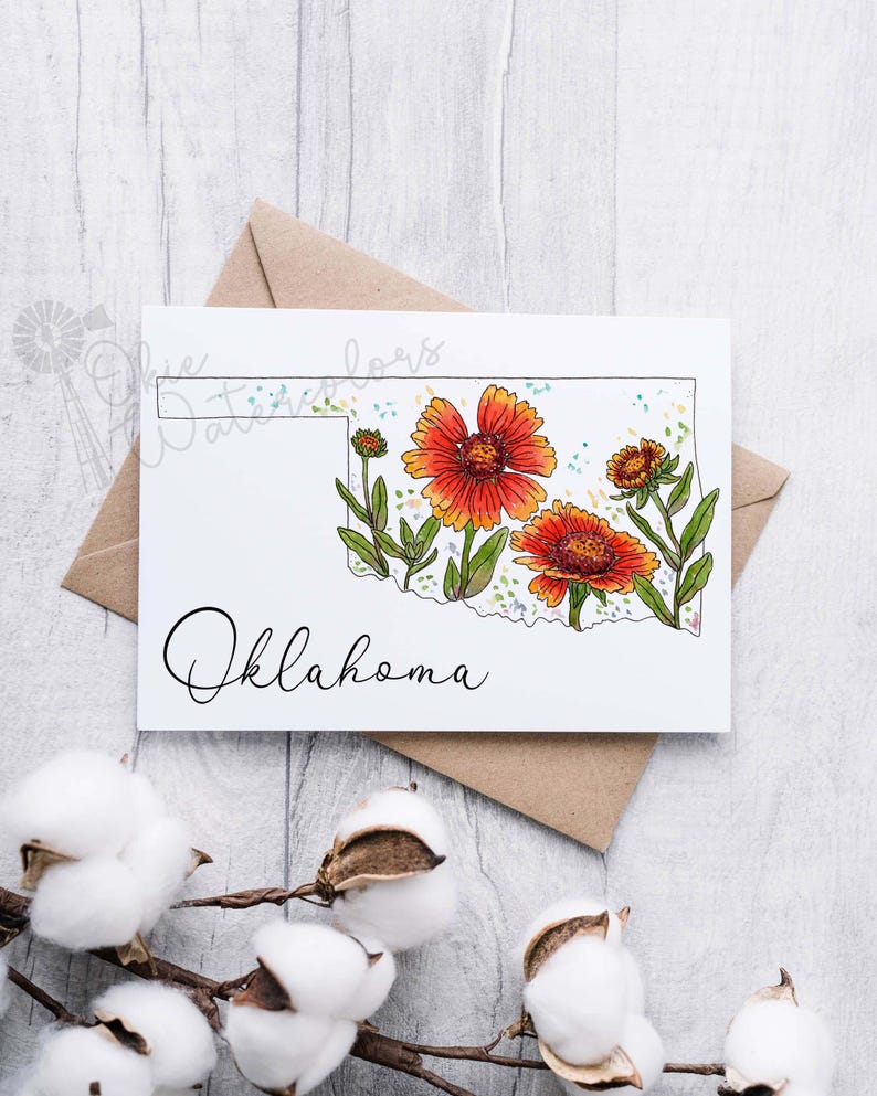K&ouml;nnte beinhalten: Eine Gru&szlig;karte mit einer Aquarell-Illustration des Bundesstaates Oklahoma mit orangefarbenen und gelben Blumen. Der Text "Oklahoma" ist in Kursivschrift unter der Illustration geschrieben.