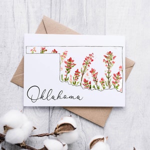 K&ouml;nnte beinhalten: Eine wei&szlig;e Karte mit einer schwarzen Umrandung des Bundesstaates Oklahoma, gef&uuml;llt mit roten und gr&uuml;nen Aquarellblumen. Das Wort "Oklahoma" ist in schwarzer Kursivschrift unterhalb der Bundesstaatenumrandung geschrieben.