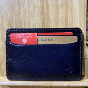 May include: Black leather card holder with a brown card insert that says "VISCONTI" and a red card insert with the text "LA PROTECTION DE L'IDENTITE" in French.