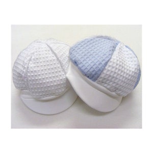 May include: Two baby hats, one white and one blue and white. The hats are made of a waffle-like fabric and have a brim.