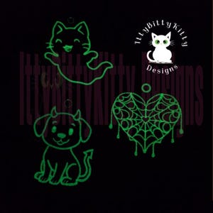 Könnte beinhalten: Schwarzer Hintergrund mit drei leuchtend grünen Halloween-Designs. Ein Katzengeist, ein Teufelshund und ein Spinnennetzherz sind abgebildet. Das Logo von Itty Bitty Kitty Designs ist ebenfalls zu sehen, mit einer weißen Katze mit grünen Augen.