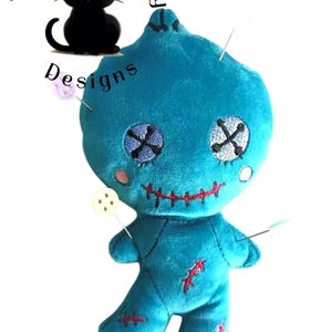 May include: A blue voodoo doll with red stitching and black X's for eyes. The doll has pins sticking out of it.