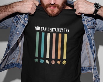 May include: A black t-shirt with the text "YOU CAN CERTAINLY TRY" and a graphic of five colorful vertical bars with a dice icon at the bottom of each bar.