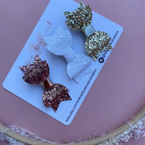 Trio av roséguld, guld och vita glittriga rosetter