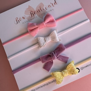 Könnte beinhalten: Set aus vier handgefertigten Haarbändern mit passenden elastischen Haarbändern. Die Schleifen sind in Pink, Weiß, Lila und gelbem Glitzer. Die Haarbänder sind in Pink, Weiß, Lila und Gelb. Das Bild enthält den Text "Bow Boulevard Handmade Hair Bows" und "www.etsy.com/ie/shop/bowboulevard".