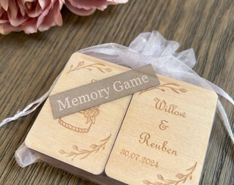 May include: A set of wooden memory game cards in a white organza bag. The cards are decorated with floral designs and the text "Memory Game". One card has the text "Willow & Reuben 30.07.2024".