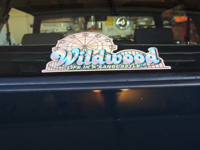 May include: A blue and pink sticker with the text "Wildwood Life in a Sandcastle" and a graphic of a Ferris wheel.