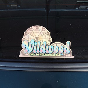 May include: A sticker featuring a colourful illustration of a Ferris wheel and the text "Wildwood Life in a Sandcastle".