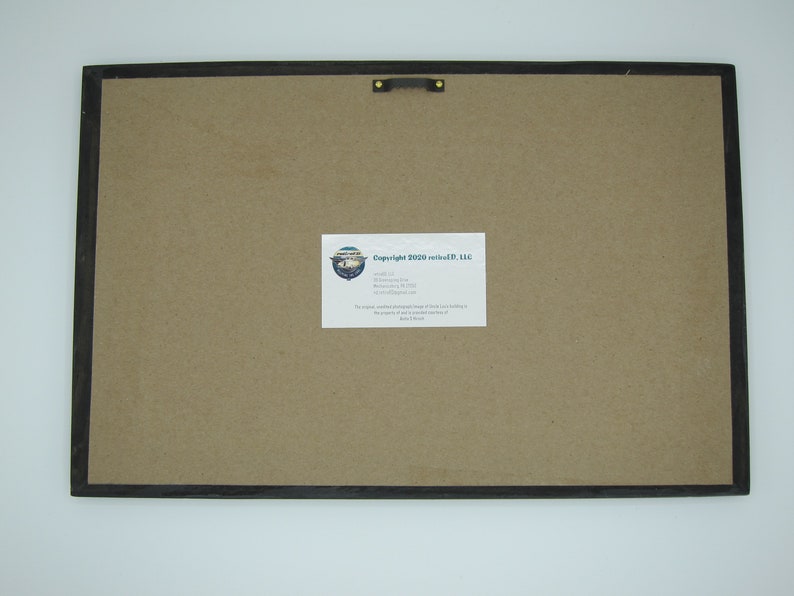 May include: The back of a framed print with a brown paper backing. A white label with the text "Copyright 2020 re:edited, LLC" is attached to the backing.