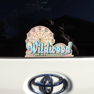May include: A pink and blue car sticker with a Ferris wheel and the text "Wildwood Life in a Sandcastle".