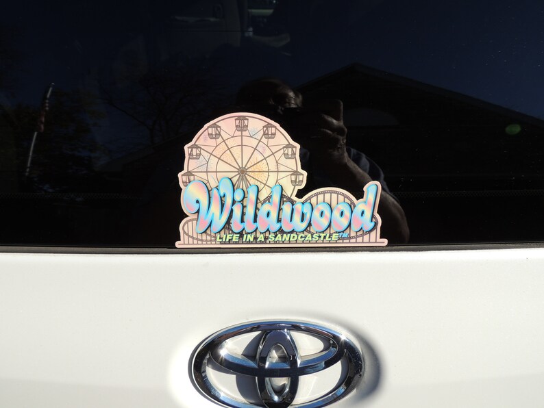 May include: A pink and blue car sticker with a Ferris wheel and the text "Wildwood Life in a Sandcastle".