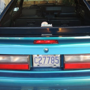 May include: Teal blue Ford Mustang with a Pennsylvania licence plate that reads "C27785 CLASSIC CAR". The car has a rear window sticker that reads "Wildwood".