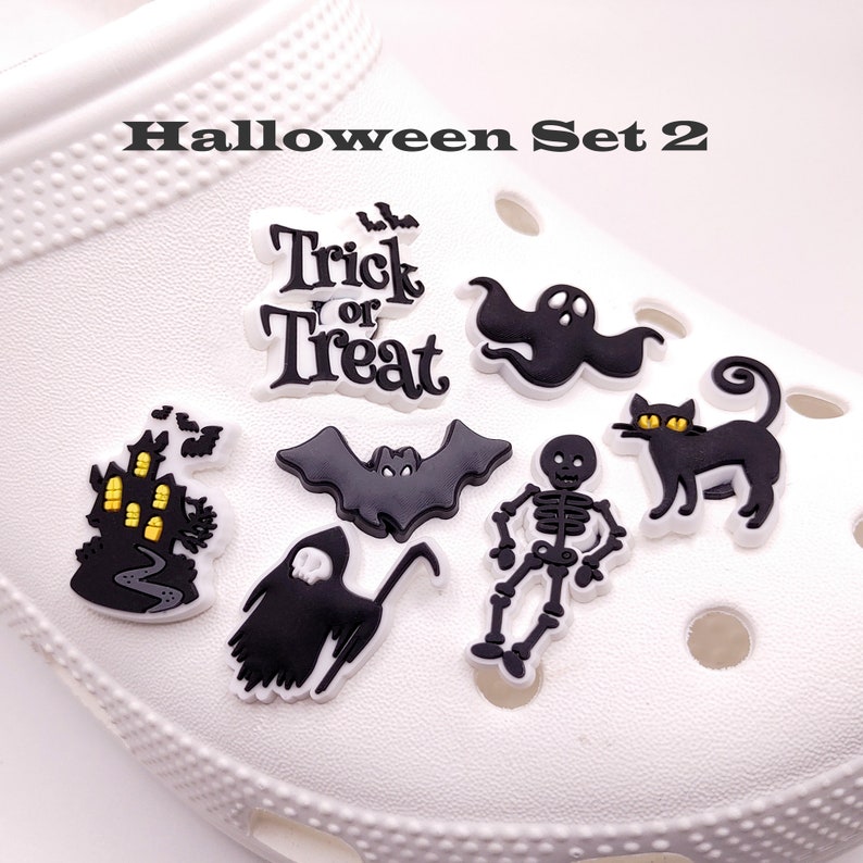 May include: Halloween themed shoe charms featuring a ghost, bat, skeleton, black cat, haunted house, and a "Trick or Treat" charm.