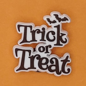 May include: White and black "Trick or Treat" Halloween shoe charm with two black bats above the text.