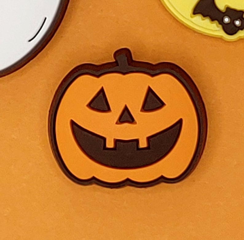 May include: Orange and brown Halloween pumpkin with a carved smiling face.