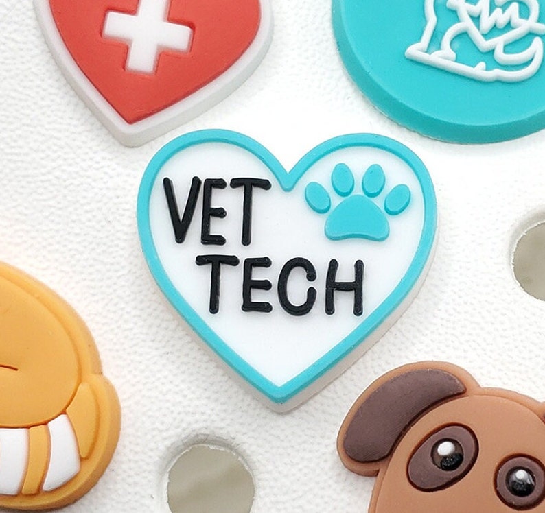 May include: A blue and white heart-shaped charm with the text "VET TECH" and a blue paw print.