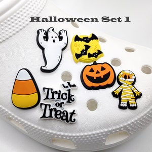 May include: Halloween Set 1 includes a ghost, a pumpkin, a candy corn, a mummy, and a "Trick or Treat" charm. These charms are perfect for decorating shoes or other accessories.