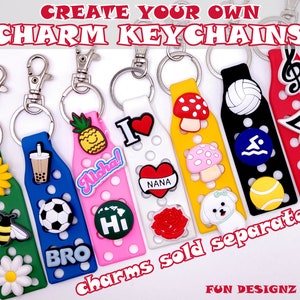 May include: Create your own charm keychains with these colourful silicone keychains. Each keychain has a different design, including a pineapple, a cup of boba tea, a football, a mushroom, a volleyball, a music note, and a bee. The charms are sold separately.
