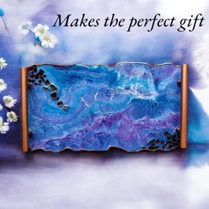 May include: A rectangular tray with a blue and purple marbled design, accented with copper-colored edges and dark embellishments. The text "Makes the perfect gift" is displayed in black script.