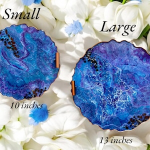 May include: Two decorative resin trays with blue and purple swirls, copper handles, and a textured edge. The small tray is 10 inches in diameter, and the large tray is 13 inches in diameter. The word "Small" and "Large" are written above each tray.