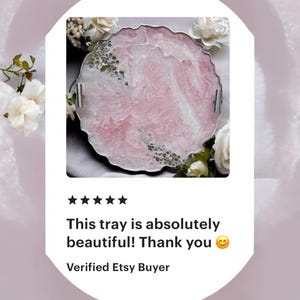 May include: A pink and white resin tray with a scalloped edge and silver handles. The tray has a marbled effect and is decorated with gold glitter.