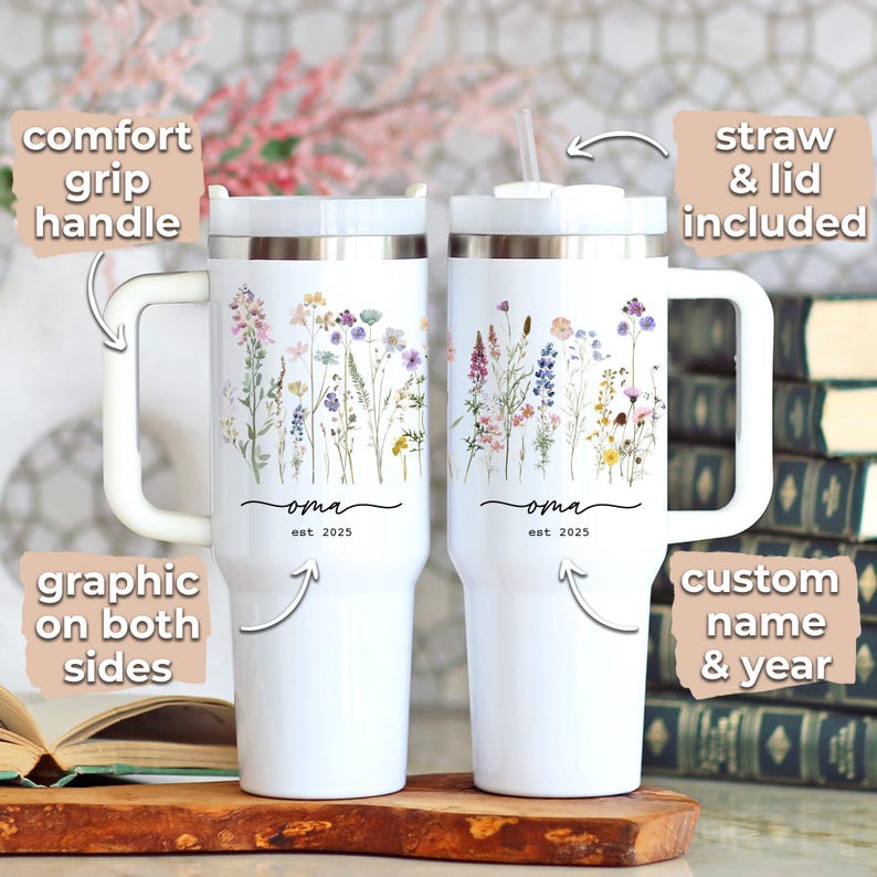May include: Two white insulated tumblers with floral designs and the word "oma" and the year "est. 2025". Each tumbler has a comfort grip handle and a straw and lid. The graphic is on both sides. Custom name and year.