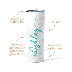 May include: White marble tumbler with a teal green inscription that reads "Ashley". The tumbler has a leak-proof sliding lid and is BPA free. It fits in most cupholders.