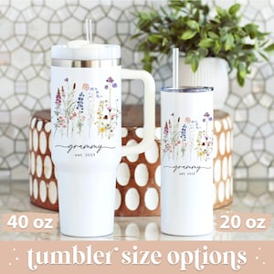 May include: White tumblers with floral designs and the word "grammy" with "est 2025". One tumbler is 40 oz with a handle, and the other is 20 oz. Both have straws. The phrase "tumbler size options" is at the bottom.