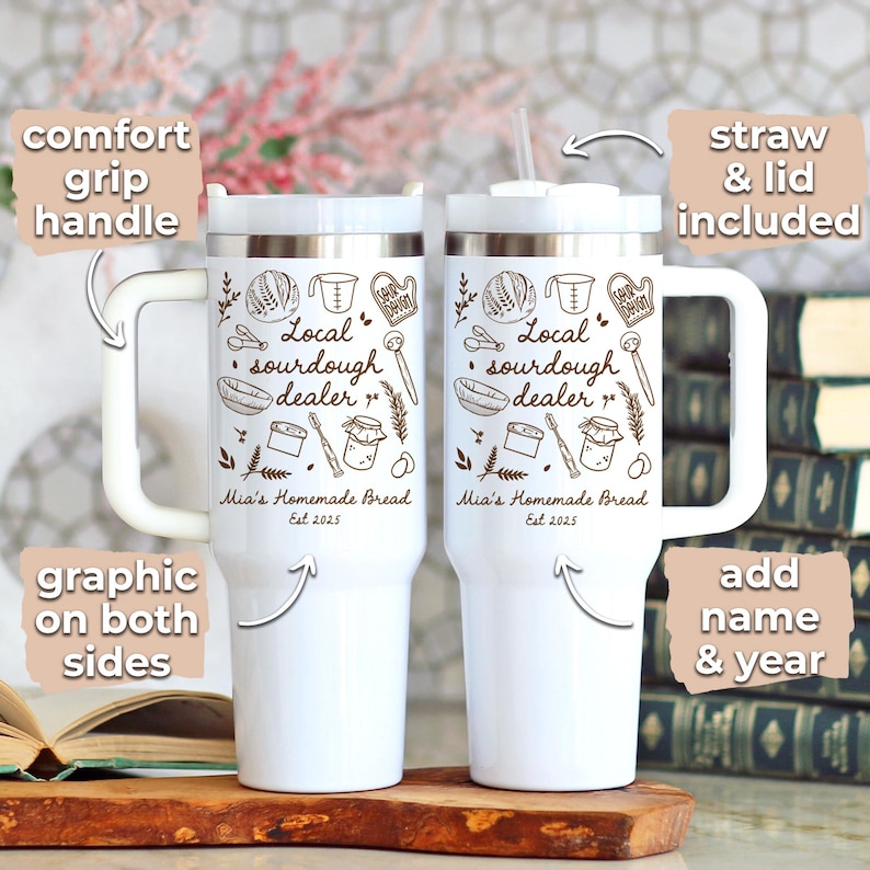 K&ouml;nnte beinhalten: Zwei wei&szlig;e isolierte Becher mit Komfortgriff, Strohhalm und Deckel. Jeder Becher hat eine Grafik mit dem Text "Local sourdough dealer" und "Mia's Homemade Bread Est 2025". Das Design ist auf beiden Seiten, mit der Option, einen Namen und ein Jahr hinzuzuf&uuml;gen.