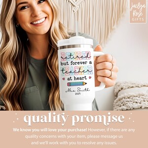 May include: White travel mug with a handle and a lid. The mug has the text "Retired but forever a teacher at heart" in colorful letters, along with a pencil graphic and the name "Mrs. Smith 2025".