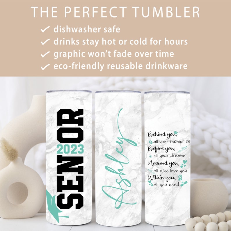 May include: Three stainless steel tumblers with white marble print. The first tumbler has the text "Senior 2023" in black with a teal graduation cap. The second tumbler has the name "Ashley" in teal script. The third tumbler has the text "Behind you, all your memories. Before you, all your dreams. Around you, all who love you. Within you, all you need." in teal with a teal graduation cap, airplane, heart, and ribbon.