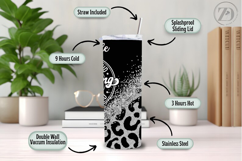 May include: A stainless steel tumbler with a black background and a silver glitter design. The tumbler has a leopard print pattern at the bottom and the words "be kind" in a circular design. It includes a straw and a splashproof sliding lid.
