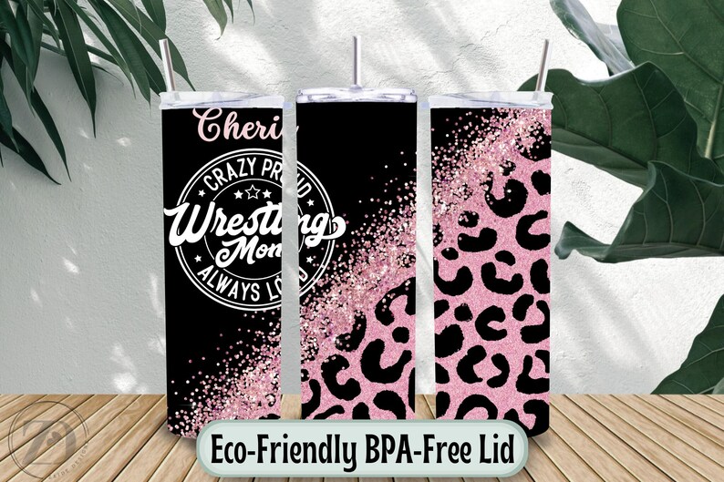 May include: Three stainless steel tumblers with lids and straws. The tumblers have a black background with pink glitter and leopard print designs. One tumbler has the text "Cheri Crazy Proud Wrestling Mom Always Loved".