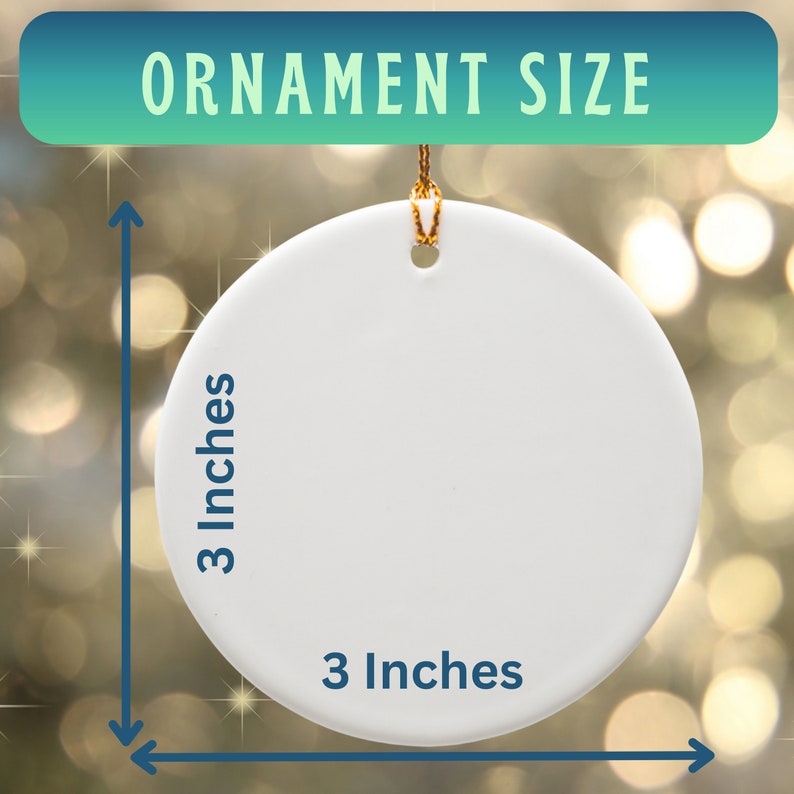 May include: A white, round ornament with a gold string for hanging. The text "ORNAMENT SIZE" is at the top. The ornament is 3 inches in diameter, as indicated by the blue arrows and text.