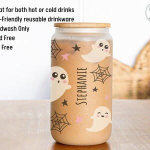 May include: A glass tumbler with a bamboo lid, decorated with cartoon ghosts, spiderwebs, and stars. The name "STEPHANIE" is printed vertically on the tumbler. The tumbler is designed for both hot and cold drinks.