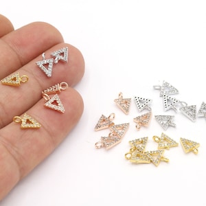 May include: Assortment of triangle-shaped charms with clear crystal accents. The charms are available in gold, silver, and rose gold finishes.