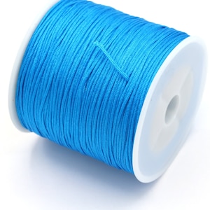 Puede incluir: Una bobina de cordón encerado azul brillante, ideal para la elaboración de joyas, macramé o manualidades.