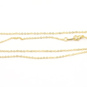 May include: A gold chain necklace with a lobster clasp closure. The chain is made of small, round links.