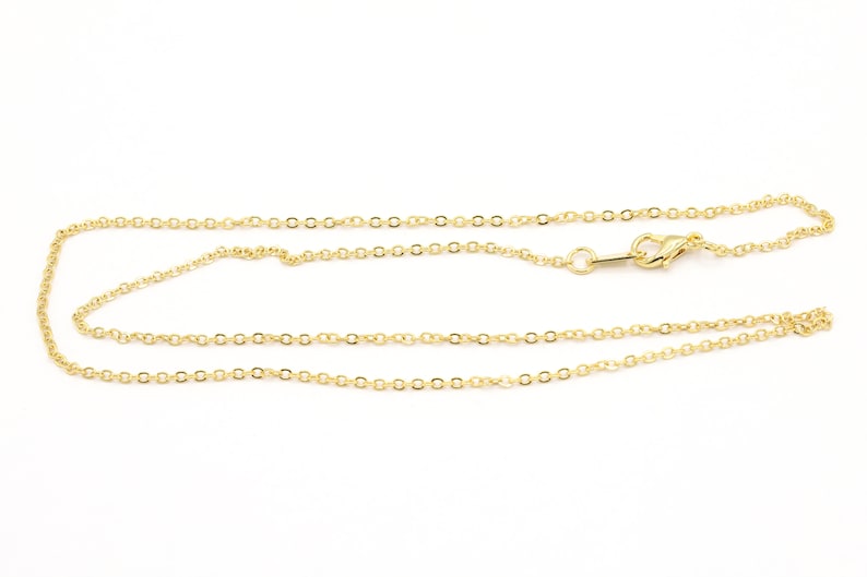 May include: A gold chain necklace with a lobster clasp closure. The chain is made of small, round links.