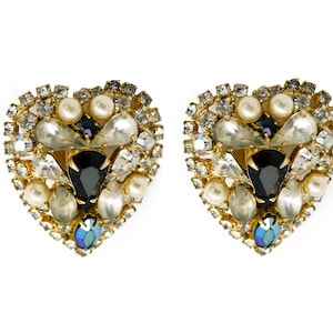 Puede incluir: Un par de pendientes en forma de corazón con un engaste de oro y un racimo de perlas blancas, diamantes de imitación transparentes y piedras azules iridiscentes.