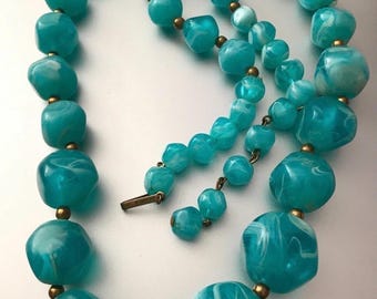 Collar vintage Kramer New York con espaciadores dorados y cuentas gruesas de lucita marmolada en azul agua firmado.