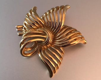 Broche vintage de flor calada en tono dorado