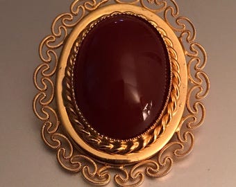 Broche vintage victoriano de cornalina con cabujón adornado con filigrana en tono dorado