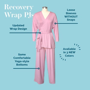 Puede incluir: Un top de pijama rosa de estilo envolvente y pantalones a juego. El top tiene cuello en V y un lazo en la cintura. Los pantalones son de estilo yoga. El texto "Recovery Wrap PJs" está en la parte superior de la imagen. El texto "Updated Wrap Design" está en el lado izquierdo de la imagen. El texto "Loose Sleeves WITHOUT Snaps" está en el lado derecho de la imagen. El texto "Same Comfortable Yoga-style Bottoms" está en el lado izquierdo de la imagen. El texto "Available in 3 NEW Colors" está en el lado derecho de la imagen.