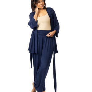 May include: A navy blue pajama set with a long-sleeved robe and wide-leg pants. The robe has a tie belt and the pants have a wide waistband.