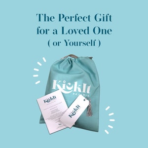 May include: A light blue drawstring bag with the text "Kicklt Pajamas" printed on the front. The bag is filled with a white card and a white tag with the same text.