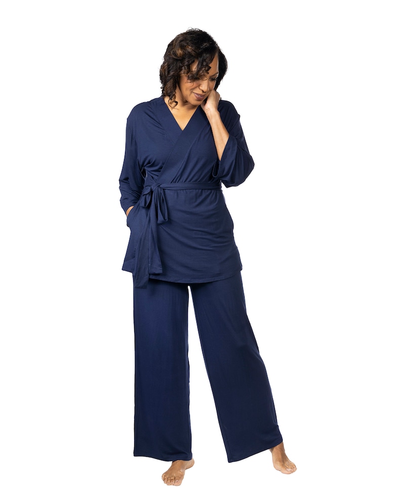 May include: A navy blue pajama set with a long-sleeved top and wide-leg pants. The top has a wrap style and a tie at the waist.