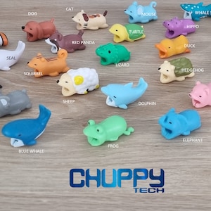 May include: A collection of colourful animal-shaped cable protectors, including a penguin, a koala, a blue whale, a frog, an elephant, a sheep, a dolphin, a hedgehog, a duck, a whale, a panda, a lion, a whale shark, a hippo, a turtle, a cat, a dog, a fish, a seal, a squirrel, a red panda, a lizard, a pig, and a shark. The cable protectors are made of soft, flexible silicone and are designed to protect your cables from damage.