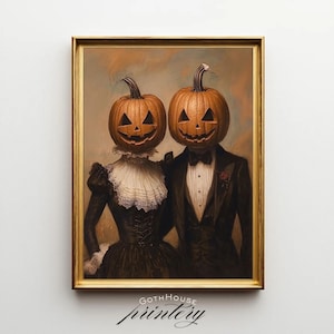 May include: A framed Halloween-themed print featuring a couple with carved pumpkin heads. The couple is dressed in formal attire, with the woman in a dark dress and the man in a tuxedo. The print has a gold frame and the text "GOTH HOUSE printery" at the bottom.