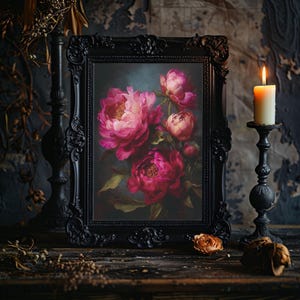 May include: A framed floral painting featuring vibrant pink peonies. The artwork is set in a black ornate frame, with a lit candle and decorative candle holder to the right. The scene is set on a dark wooden surface.